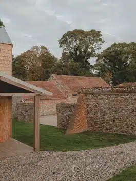 Courtyard context traditional rubble flint walls and braced brickwork. The geometries of pitch and mass talking to each other Alexander Hills Architects