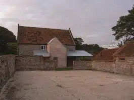 View of the new extension and veranda that wraps the farmhouse and provides necessary cover Alexander Hills Architects